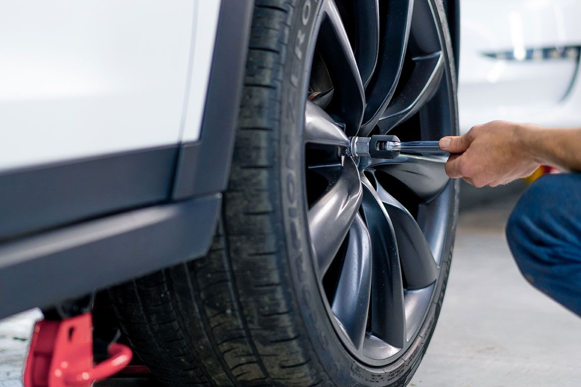auto-mechanic-man-changing-a-wheel-on-a-luxury