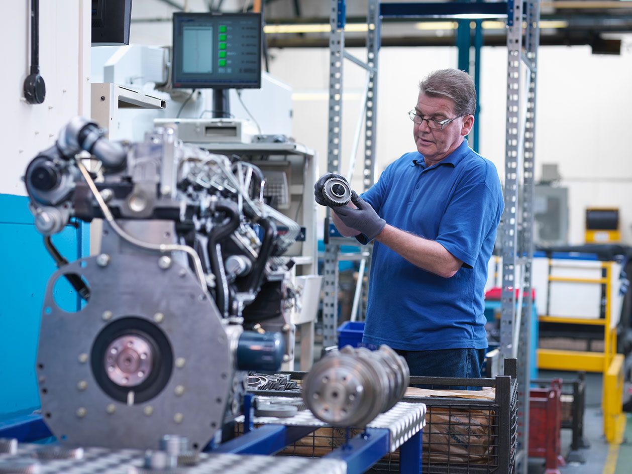 engineer-with-gear-wheel-and-diesel-engine-in-engi