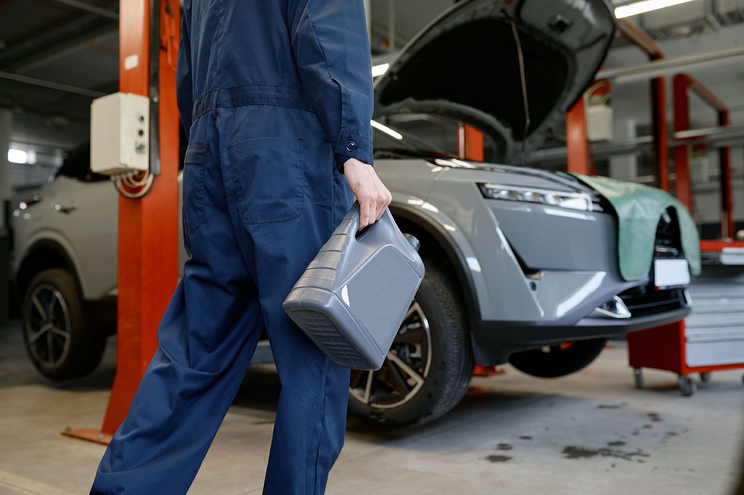 closeup-auto-mechanic-carrying-bottle