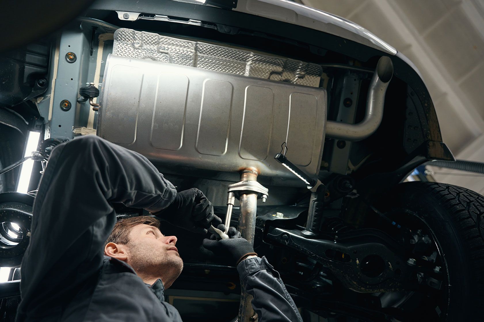 professional-male-checking-exhaust-resonator