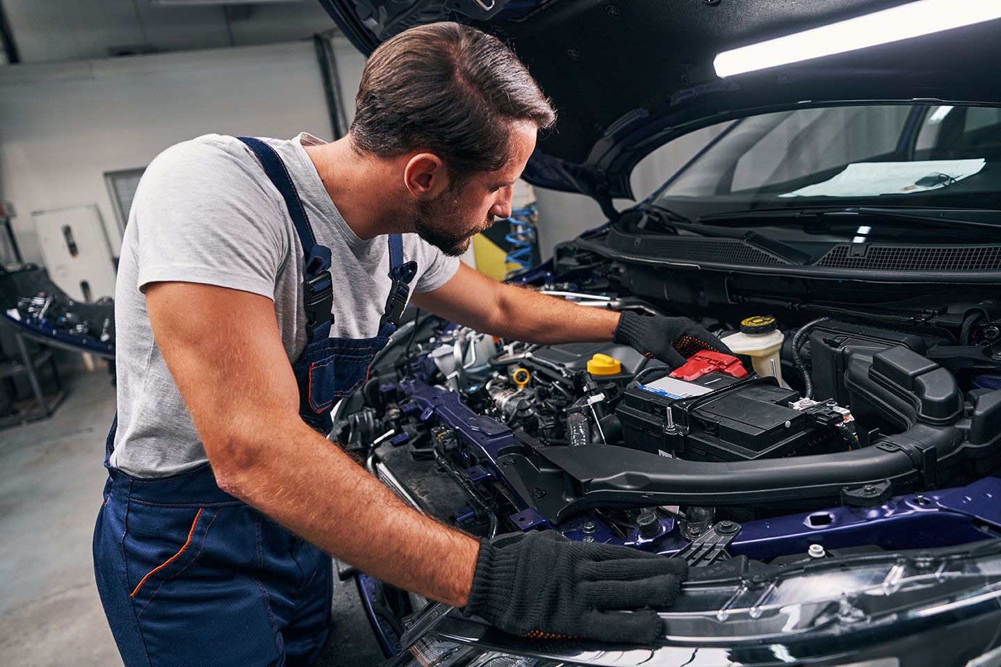 professional-mechanic-adjusting-red-battery-under