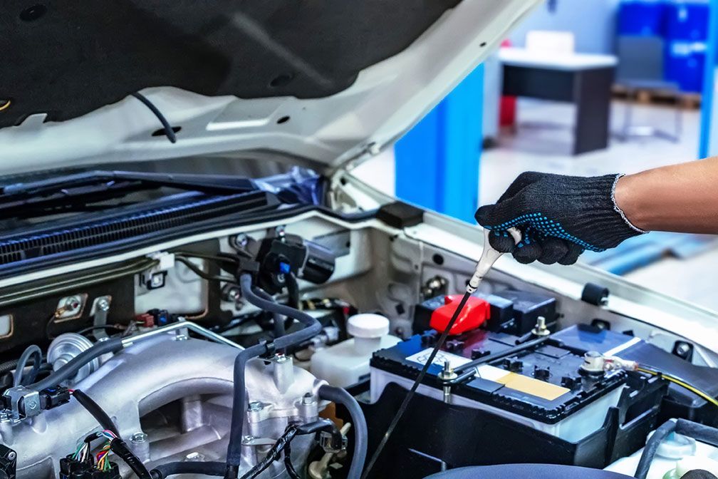 auto-mechanic-working-with-open-car-hood-in-garage