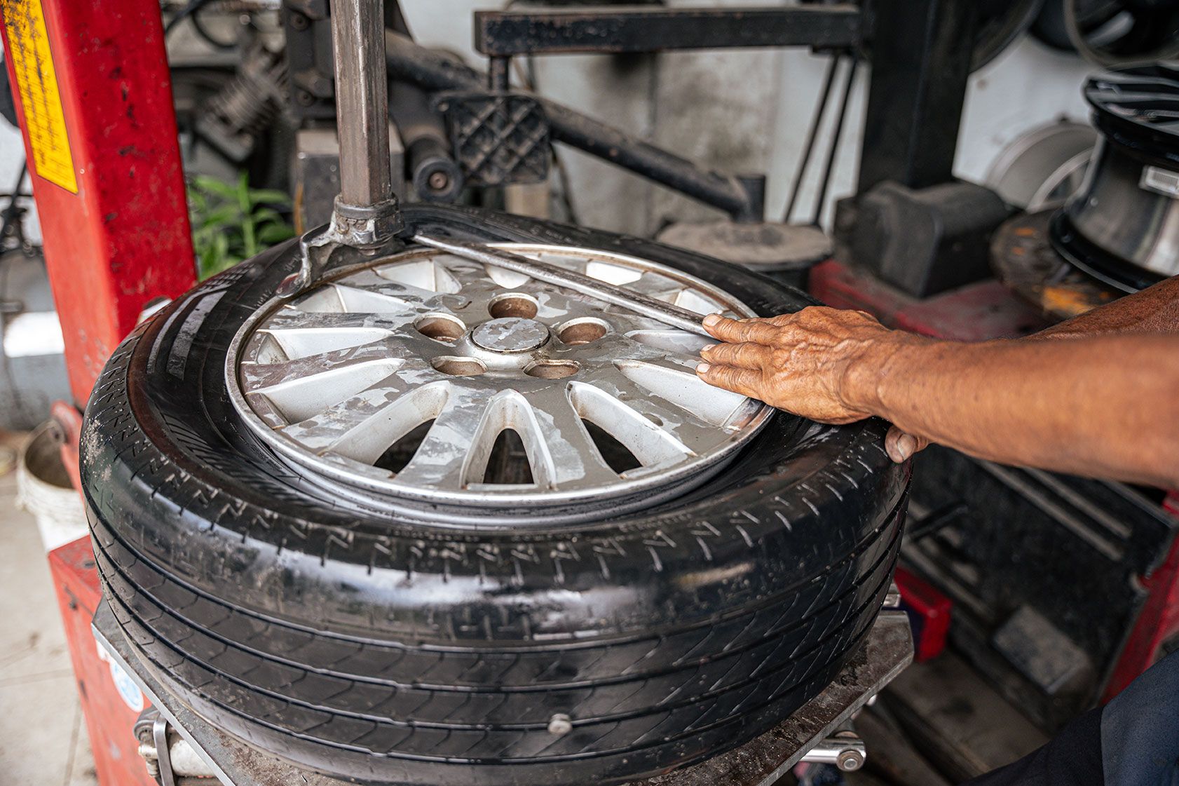 car-mechanic-repairs-punctured-tire-2024-07-26-20-38-40-utc