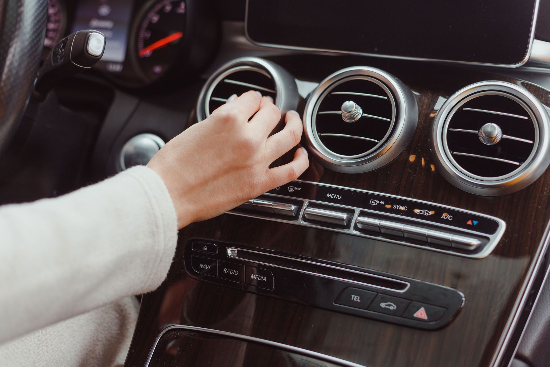 hand-of-woman-turning-on-car-air-condition-system